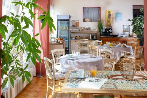 a restaurant with tables and chairs and a kitchen at HÖTEL LE CASTELLAN in Istres