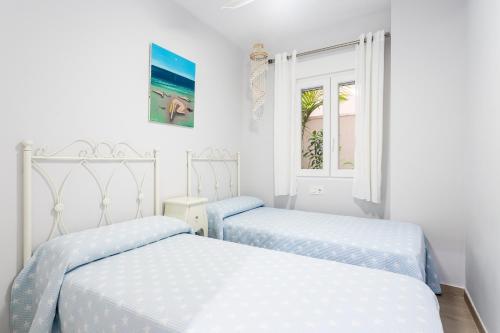 - 2 lits dans une chambre aux murs blancs dans l'établissement Apartamento Columbretes, à San Juan de Alicante