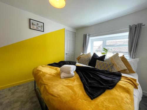 a bedroom with a large bed with a yellow wall at Heritage House By MGroupSA - Free Parking in Nantyglo