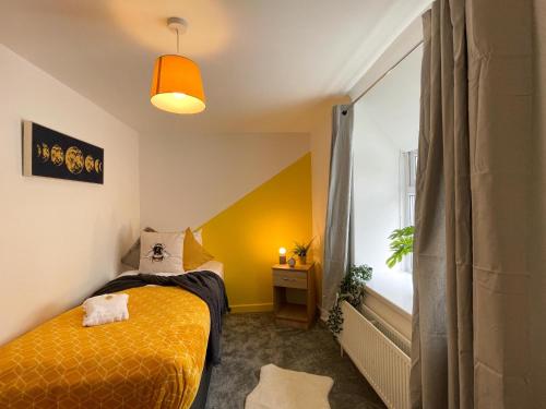 Un dormitorio con una cama amarilla y una ventana en Heritage House By MGroupSA - Free Parking, en Nantyglo