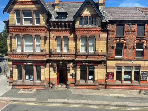 un vieux bâtiment en briques avec une porte rouge dans une rue dans l'établissement 264 The Road End, à Liverpool
