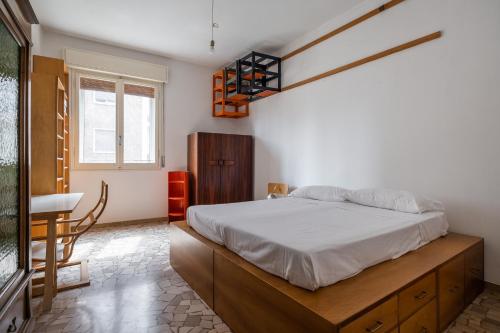um quarto com uma cama, uma mesa e uma janela em Nel cuore della città universitaria by Wonderful Italy em Bolonha