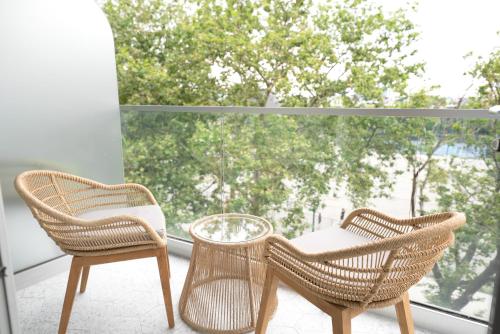 two rattan chairs and a table on a balcony at CODA Williamsburg in Brooklyn