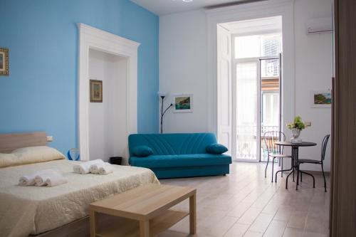 um quarto azul com uma cama e uma cadeira azul em Donna Laura Suite em Nápoles