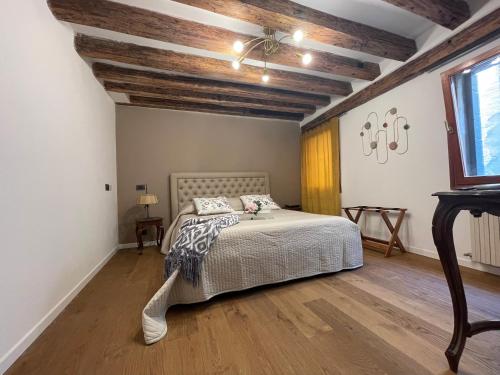 a bedroom with a bed and a wooden ceiling at Ca' ai Sospiri in Venice