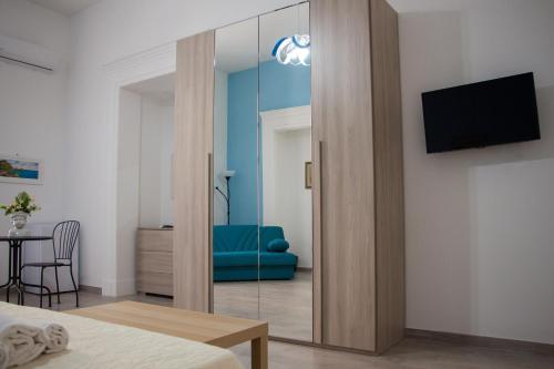 um quarto com um espelho, um sofá azul e uma mesa em Donna Laura Suite em Nápoles