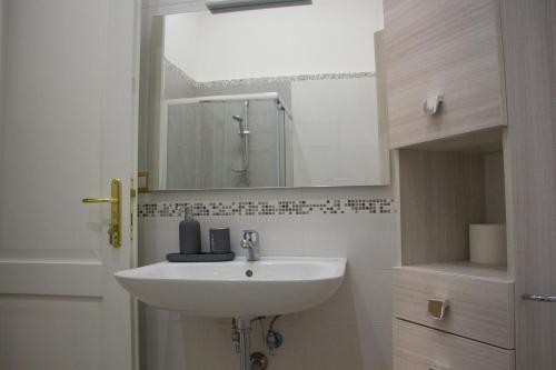 ein Badezimmer mit Waschbecken und Spiegel in der Unterkunft Donna Laura Suite in Neapel