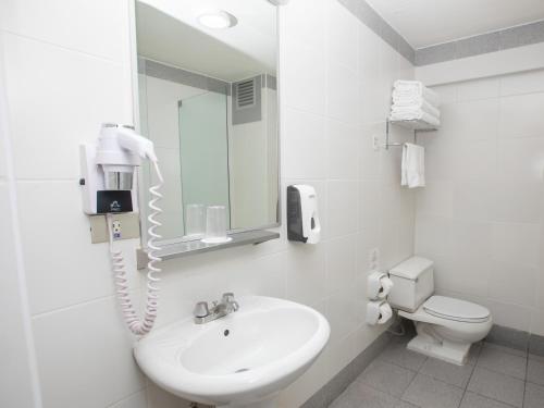 baño blanco con lavabo y teléfono en Casa Andina Standard Arequipa, en Arequipa