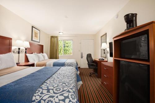 Habitación de hotel con 2 camas y TV de pantalla plana. en Days Inn by Wyndham Champaign/Urbana, en Champaign