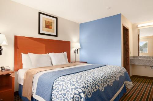 a hotel room with a large bed and a window at Days Inn by Wyndham Champaign/Urbana in Champaign