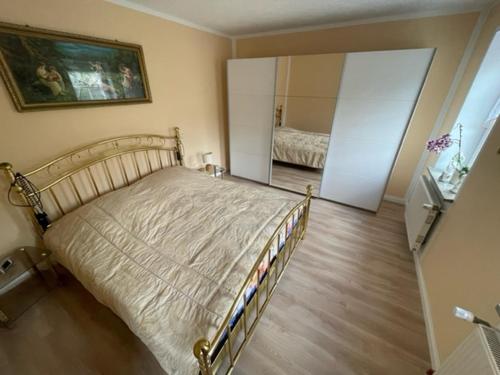 - une chambre avec un grand lit et un miroir dans l'établissement Fewo am Teich, à Laage