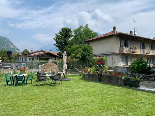 einen Garten mit Tisch und Stühlen und ein Haus in der Unterkunft Acchiappasogni Holiday House in Malgrate