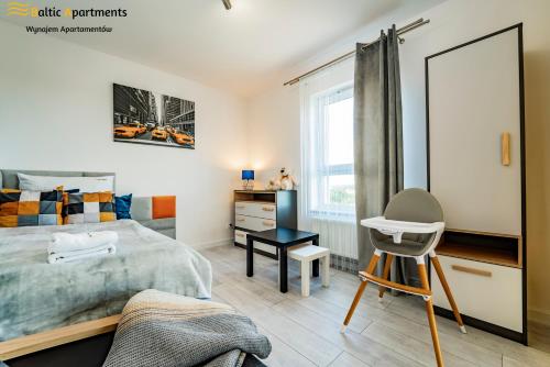 sypialnia z łóżkiem, biurkiem i lustrem w obiekcie Baltic Apartments - Sun Towers w Świnoujściu