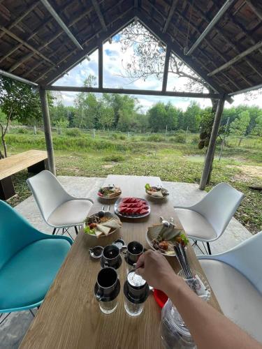 a person sitting at a table with food on it at Thôn Hoa Sen in Thôn Xuân Lỗ