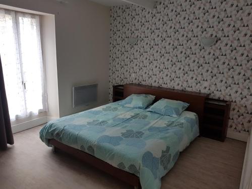 een slaapkamer met een bed met een blauw dekbed bij Aubaterra in Aubeterre-sur-Dronne