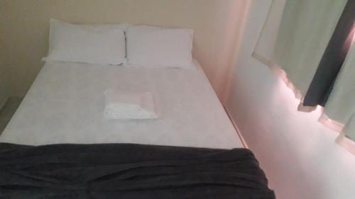 uma pequena cama num quarto com duas almofadas em Espaço do Adilson é aconchegante no Rio de Janeiro