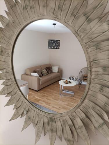 un miroir reflétant un salon avec un canapé dans l'établissement Eaton, à Saint-Malo