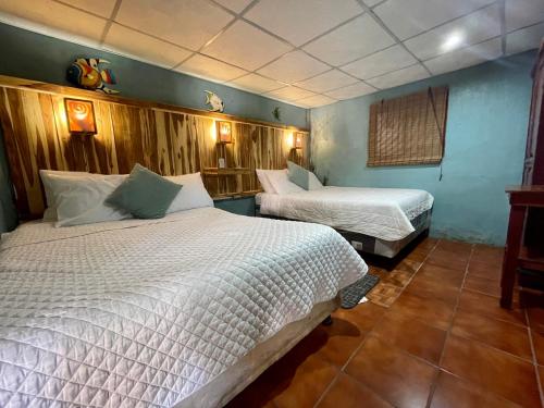 a bedroom with two beds in a room at Johnnys Place Hotel in Monterrico