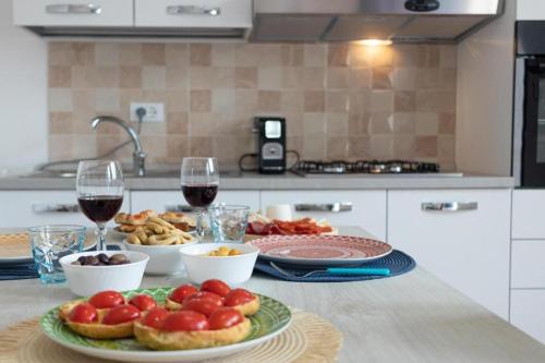 a table with a plate of food and glasses of wine at intero appartamento poseidon 46 mq in Fasano