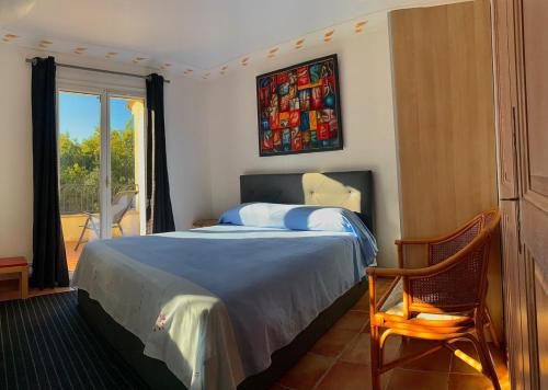 une chambre avec un lit, une chaise et une fenêtre dans l'établissement Bellevue Maison de pêcheur, à Cogolin