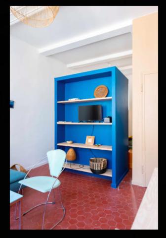 STUDIO ** HYPER CENTRE ** COEUR NOAILLES في مارسيليا: خزانة زرقاء مع كرسي في الغرفة