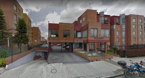 a parking lot in front of a brick building at Mirador del parque in Bogotá