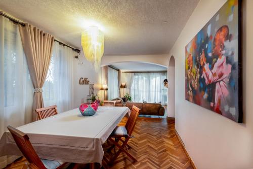 a dining room with a white table and chairs at Ewange - A Casa Mia in Kampala