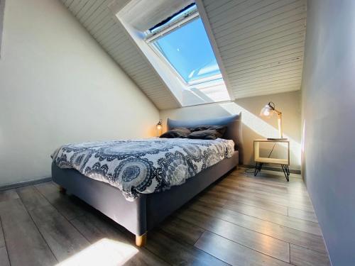 um quarto com uma cama num sótão com uma janela em Duplex 45 m2, 8 couchages, vue imprenable em LʼHuez