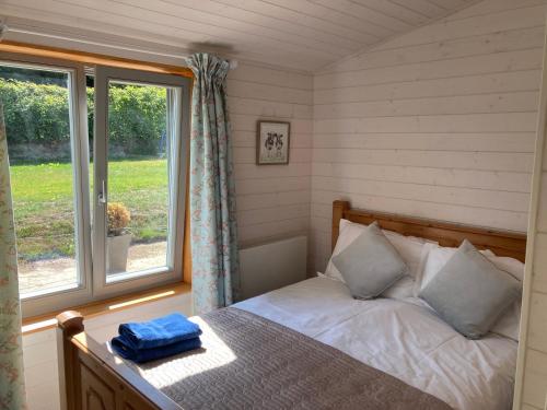 a bedroom with a bed and a window at Stag Lodge School House Farm in Leighton