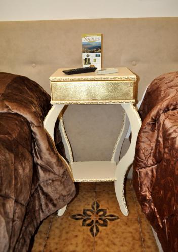 a white end table with a gold top at Hotel des Artistes in Naples
