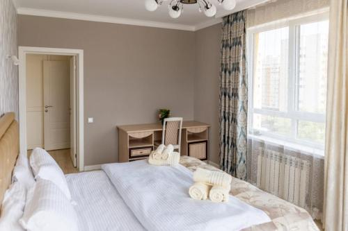 une chambre avec un grand lit avec des serviettes dessus dans l'établissement Квартира посуточно Бизнес класса в ЖК Асыл Тобе, à Almaty