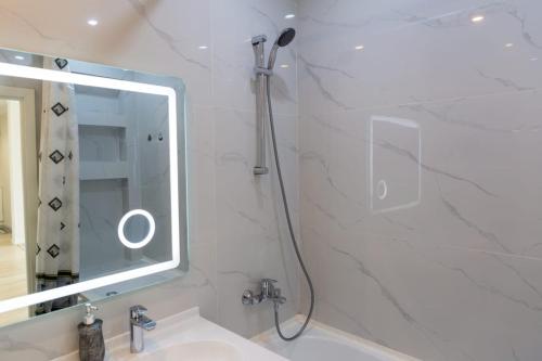 une salle de bains avec douche, lavabo et miroir dans l'établissement Квартира посуточно Бизнес класса в ЖК Асыл Тобе, à Almaty