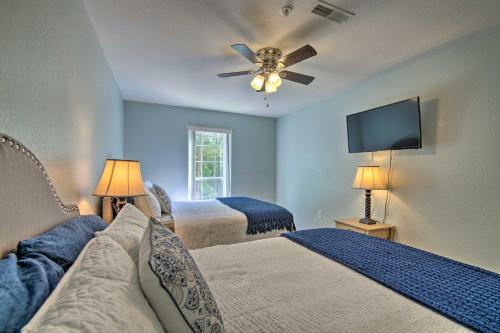 a bedroom with two beds and a flat screen tv at Bright Ozarks Condo with Balcony and Lake Views! in Kimberling City