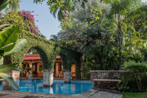 un jardín con piscina y un edificio en La Joyita Cuernavaca, en Cuernavaca