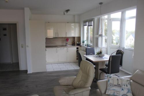een keuken en een woonkamer met een tafel en stoelen bij Grüntal Residenz I Whg 6 in Grömitz
