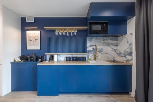 una cocina con armarios azules y fregadero en Apartament Centrum Gdańska blisko Starego Miasta, en Gdansk