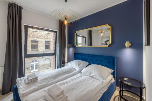 a blue bedroom with a large bed and a mirror at Apartament Centrum Gdańska blisko Starego Miasta in Gdańsk