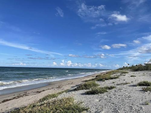 a beach with the ocean on a sunny day at Comfy Beach House on Vero Beach in Vero Beach