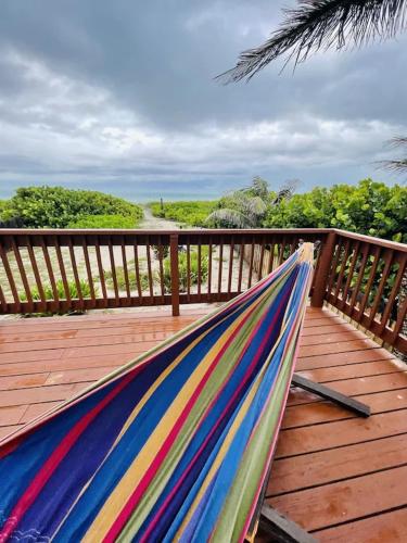 a hammock on a deck with a view of the ocean at Comfy Beach House on Vero Beach in Vero Beach