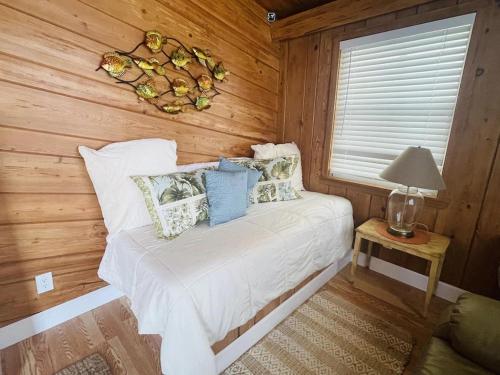 a bedroom with a bed with wooden walls and a window at Comfy Beach House on Vero Beach in Vero Beach