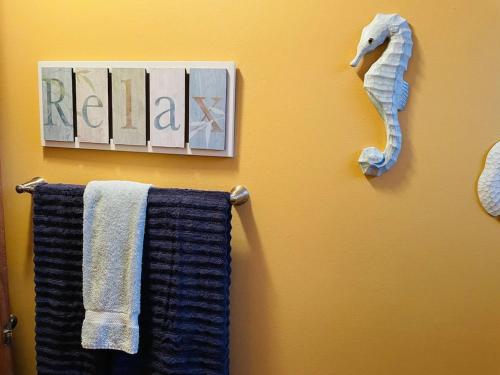 a bathroom with towels and a seahorse on the wall at Comfy Beach House on Vero Beach in Vero Beach