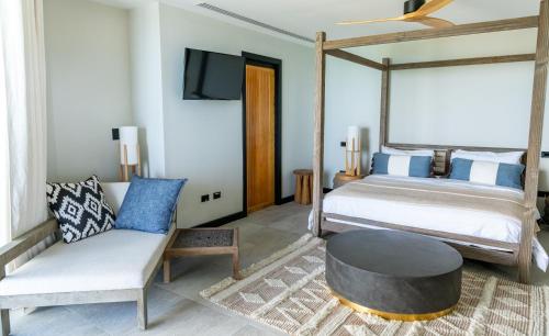 a bedroom with a bed and a couch and a table at Tamarind Hills Resort & Villas in Johnsons Point