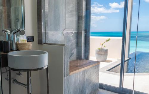 a bathroom with a sink and a view of the ocean at Tamarind Hills Resort & Villas in Johnsons Point