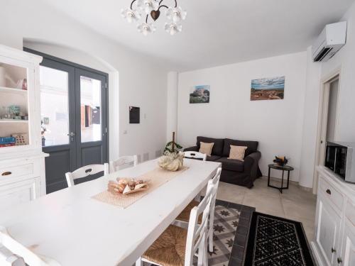 a kitchen and living room with a white table and chairs at Affittacamere Solki in SantʼAntìoco