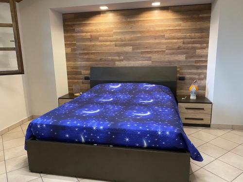 łóżko z niebieską kołdrą w pokoju w obiekcie Casa vacanze fra gli ulivi w mieście Morano Madonnuccia