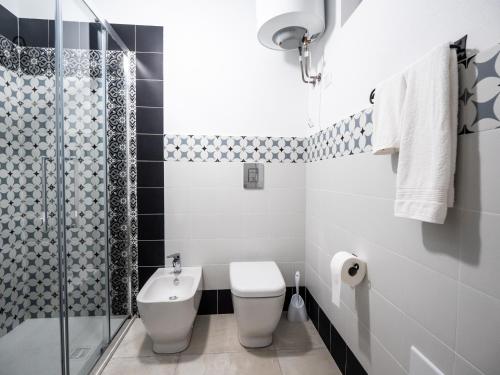 a bathroom with a toilet and a glass shower at Affittacamere Solki in SantʼAntìoco