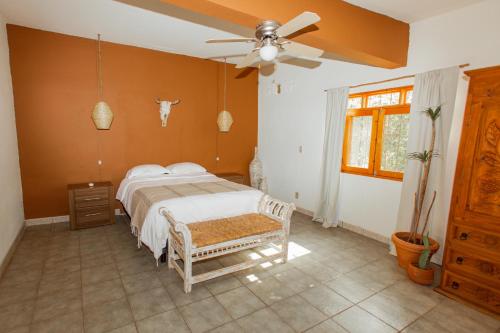 Schlafzimmer mit einem Bett und einem Deckenventilator in der Unterkunft Cien Palmas- Authentic Mexican Casita 1 -Downtown in Todos Santos