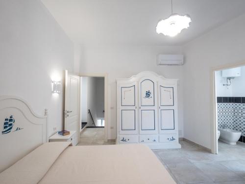 a white bedroom with a bed and a bathroom at Affittacamere Solki in SantʼAntìoco