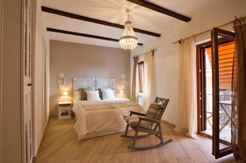 ein Schlafzimmer mit einem Bett, einem Stuhl und einem Kronleuchter in der Unterkunft Cheerful and cosy home in beautiful Nemi in Nemi