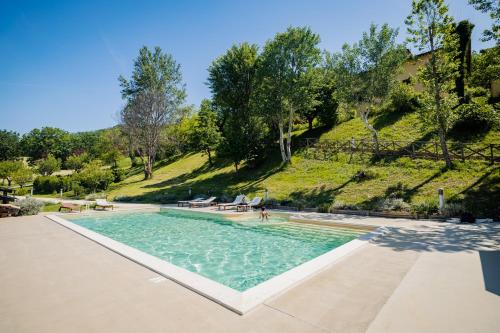 a swimming pool with a hill in the background at L'Incanto dei Sibillini in Cessapalombo